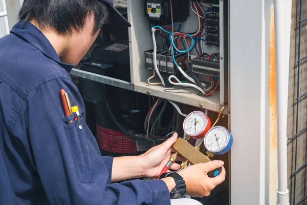 Técnico está comprobando el aire acondicionado —  Fotos de Stock