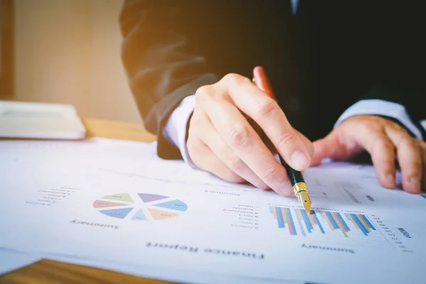 Geschäftsmann mit Stift zeigt auf zusammenfassende Berichtstabelle — Stockfoto