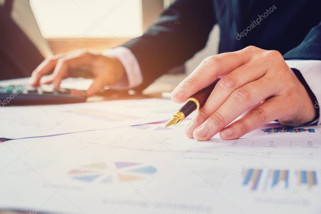 Businessman's hands with calculator counting making notes at hom