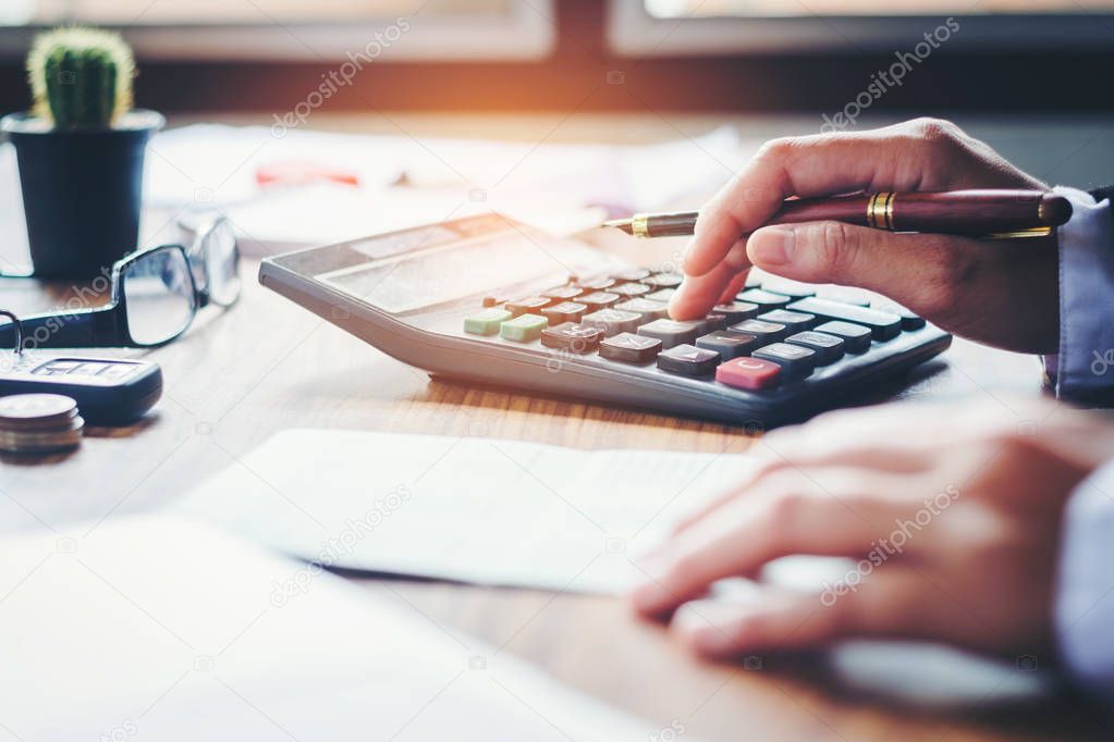 Businessman's hands with calculator and cost at the office and F