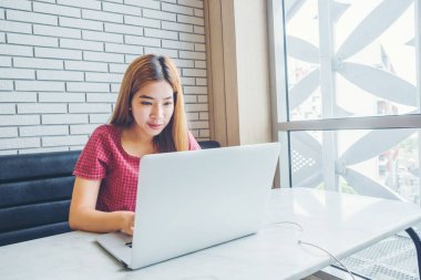 Asyalı kız laptop.female freelan ile bir kahve dükkanında çalışan