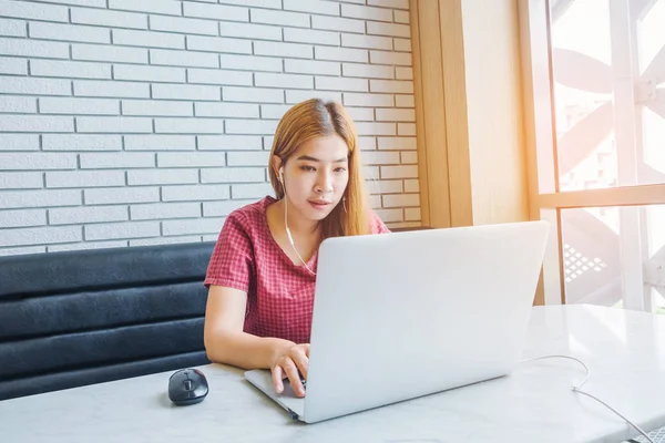 Chica asiática trabajando en una cafetería con una laptop.female freelan — Foto de Stock