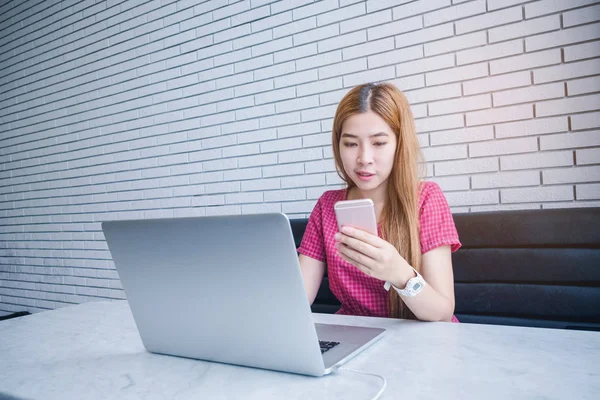Asiática chica trabajando en una cafetería sentado con teléfono móvil un — Foto de Stock