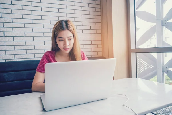 Chica asiática trabajando en una cafetería con una laptop.female freelan — Foto de Stock