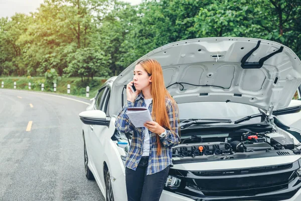 Joven mujer pidiendo ayuda con su coche roto por t — Foto de Stock