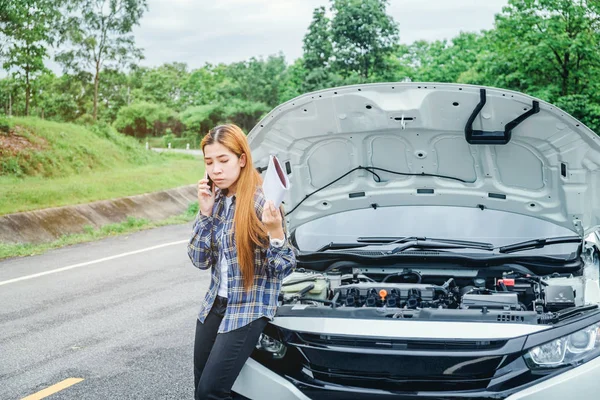 Joven mujer pidiendo ayuda con su coche roto por t — Foto de Stock