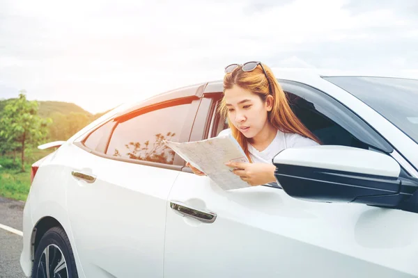 Feliz hermosa chica viajando en un coche hatchback con mapa — Foto de Stock