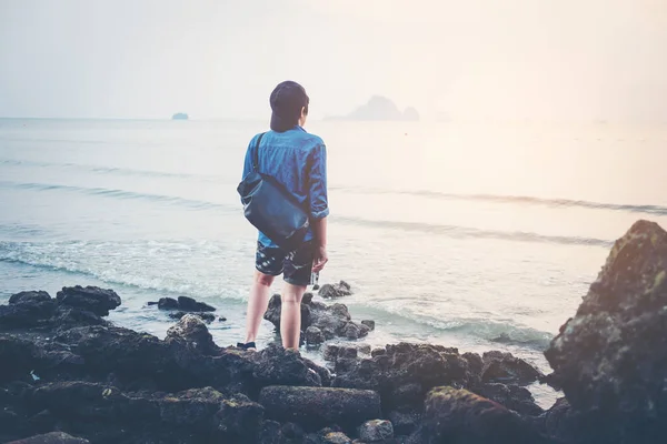 Man turned back to the camera looking at the sea, relaxed, conce