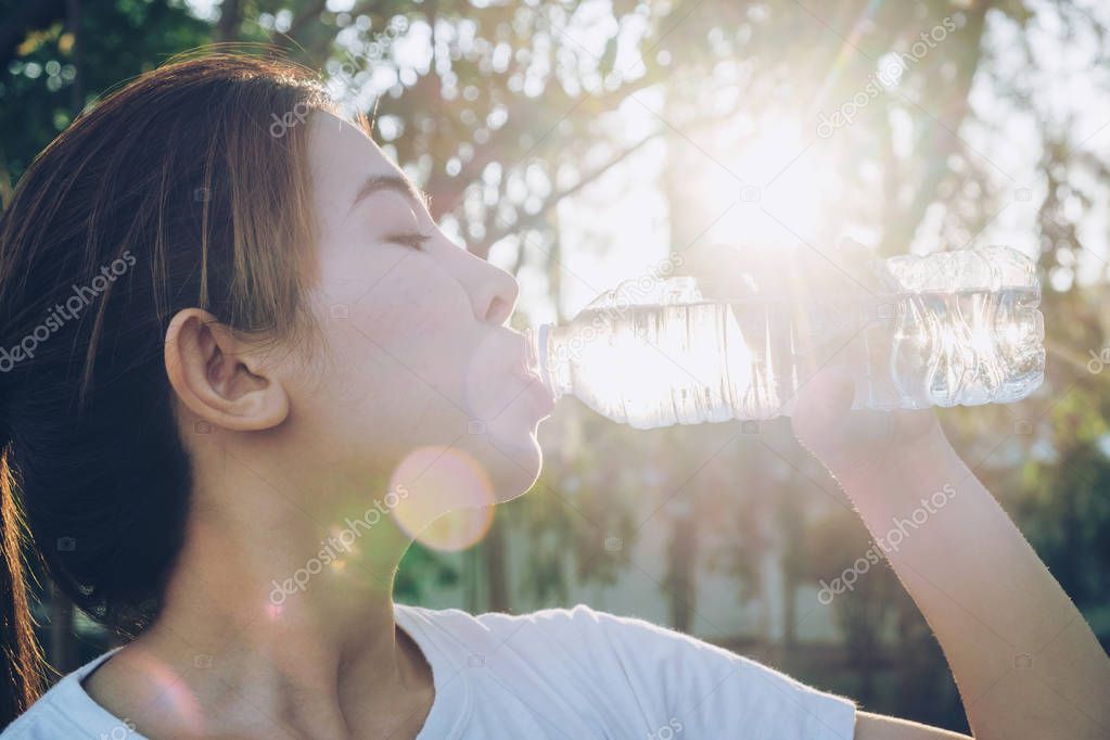 Fitness beautiful woman drinking water and sweating after exerci