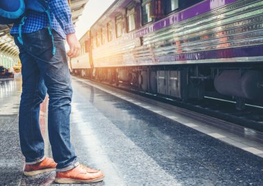 Gezgin adam tren demiryolu platformu üzerinde bekler