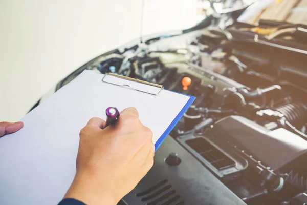 Mechaniker mit Klemmbrett für Serviceauftrag in der Werkstatt. — Stockfoto