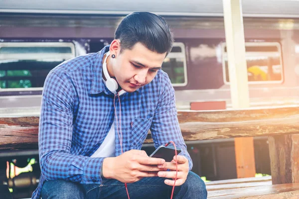 Tablet ve telefon üzerinde sta tren bekliyorsun kullanan seyahat adam