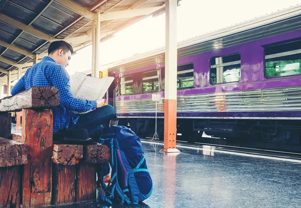 Turist backpacker tren istasyonunda seyahat etmek harita kullanarak