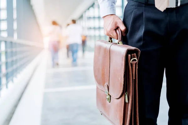 Empresario sosteniendo un maletín de viajeros caminando al aire libre — Foto de Stock