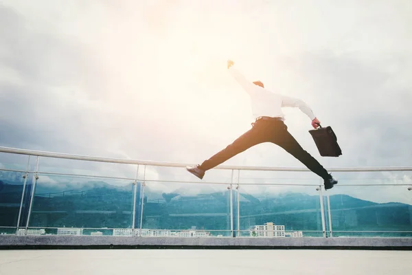 Businessman Jump on a roof and looking at city Success  concept