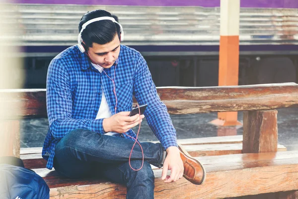 Tren istasyonunda cep telefonu kullanan adam seyahat