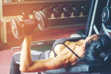 Asya spor kadın dumbbell ağırlıkları içinde jimnastik salonu ile yapıyor