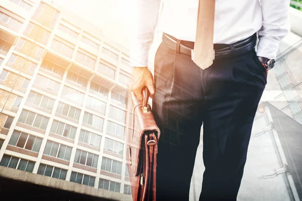 Empresario sosteniendo un maletín de viajeros caminando al aire libre — Foto de Stock