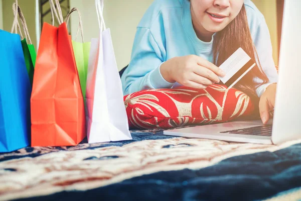 Mujer de compras en línea utilizando el ordenador portátil con tarjeta de crédito disfrutando en —  Fotos de Stock