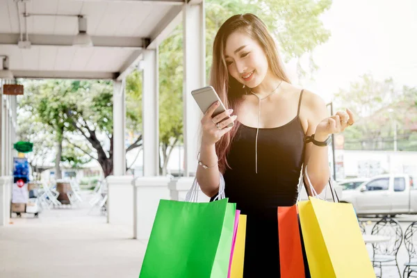 Frau nutzt Handy und genießt Einkaufsstraße — Stockfoto