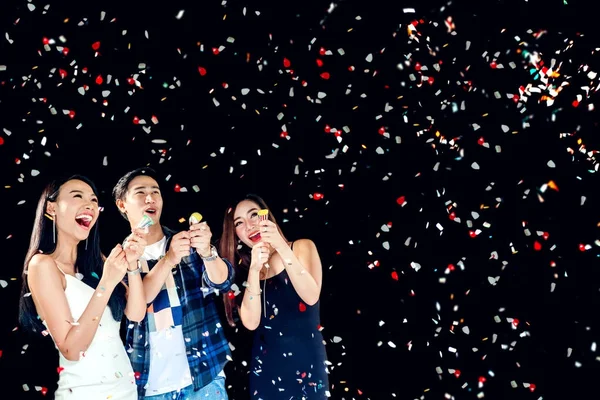 Celebration party group of asian young people holding confetti h