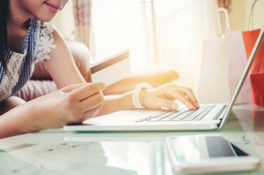Kadın alışveriş online olarak kredi kartı zevk ile dizüstü bilgisayar kullanarak 