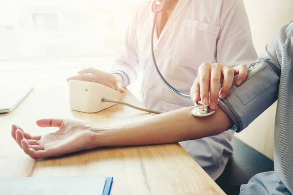 Dokter mengukur tekanan darah arteri wanita pasien di lengan. — Stok Foto