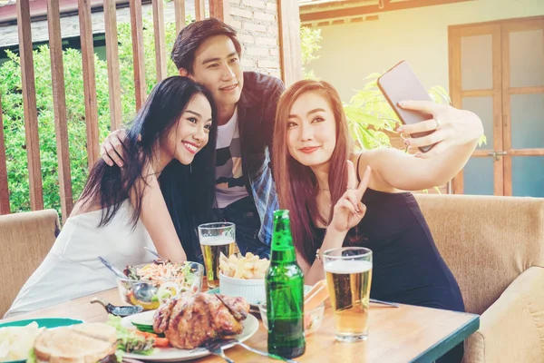 Grupo de amigos están tomando selfie y comer alimentos son felices enj — Foto de Stock