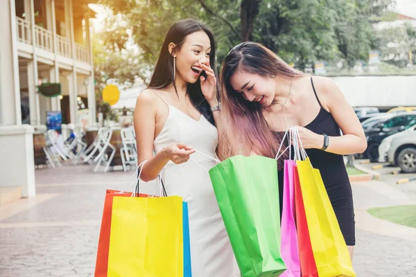 Boldog ázsiai nők barátság élvezi kiadások bevásárló táskák — Stock Fotó