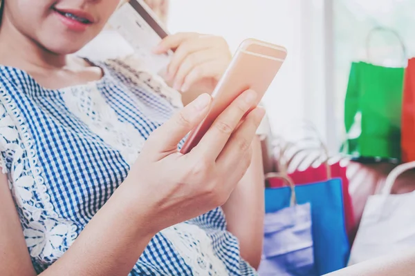 女人购物网上用信用卡享受智能手机 — 图库照片