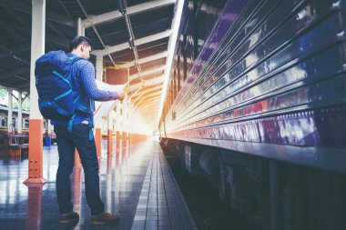 Turist backpacker tren istasyonunda seyahat etmek harita kullanarak