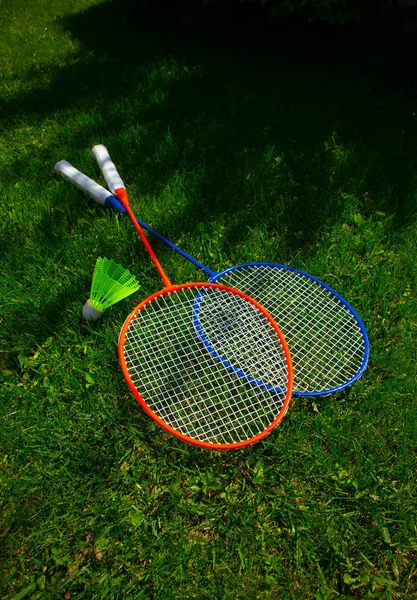 Two badminton racket on the sunny bright grass green fresh backg — Stock Photo, Image