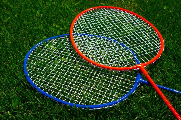Dois badminton raquete no ensolarado grama brilhante verde fresco backg — Fotografia de Stock