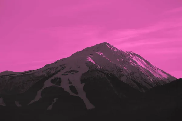 Bela vista do pôr do sol sobre os altos picos das montanhas de inverno, no — Fotografia de Stock