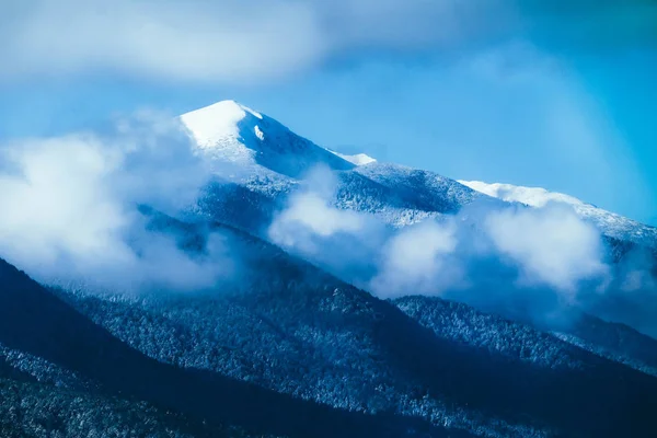 Belle montagne nebbiose alte cime coperte di neve e ghiaccio . — Foto Stock