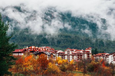 Foggy mountain village. Alpine chalet houses in a small city, fa