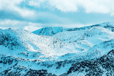 Yüksek dağlık Himalaya dağlarının zirvesi manzarası, güzel doğal kış arkaplanı. Buzlu tepe üstü, bulutlu arkaplan.