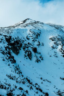 Yüksek dağlık Himalaya dağlarının zirvesi manzarası, güzel doğal kış arkaplanı. Buzlu tepe üstü, bulutlu arkaplan.