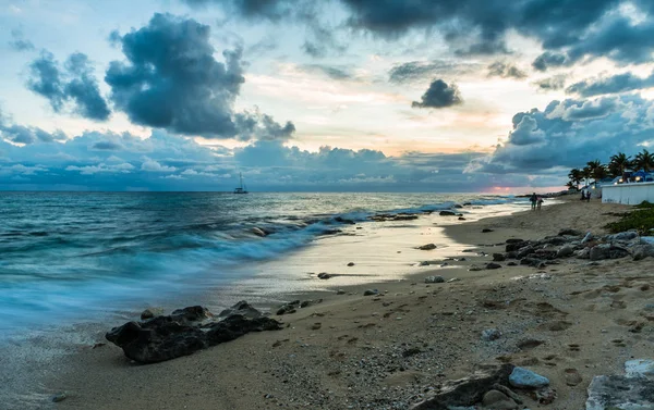 Tropischer Sonnenuntergang mit Meer und Sandstrand im Vordergrund — Stockfoto