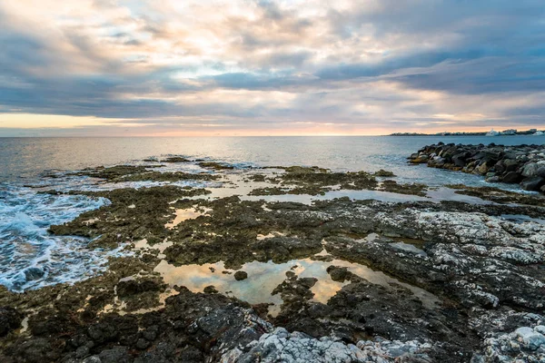 Tropischer Sonnenuntergang mit Meer und Korallen im Vordergrund — Stockfoto