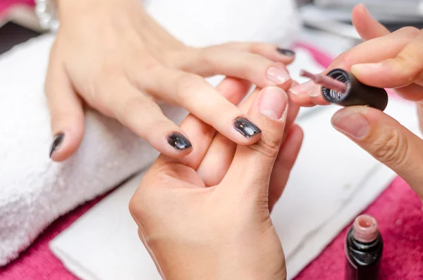 Mujer aplicando esmalte de uñas rosa — Foto de Stock