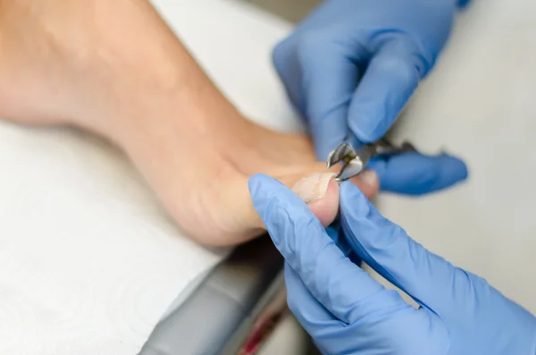 Mujer joven cortando uñas de los pies, primer plano — Foto de Stock