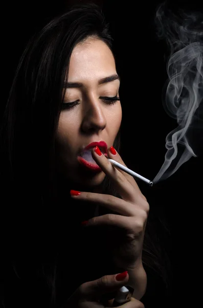 Retrato da bela menina elegante fumar cigarro no fundo preto . — Fotografia de Stock