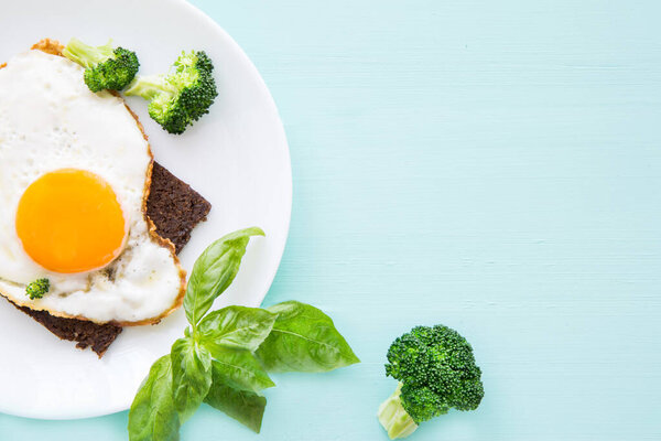 Вкусные тосты с жареными яйцами и листьями базилика, пространство для копирования, вид сверху
. 