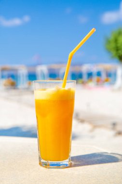 Güneşli sahilde sağlıklı taze portakal suyu. Tatil konsepti. Yaz tatili. 