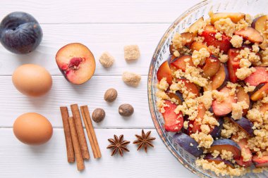 Ezilmiş erik ev yapımı turta malzemeleri beyaz ahşap masa, üst manzara. 