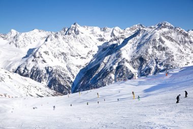 Yokuş aşağı kayak yapan kayakçılar, Tirol (Tyrol) Avusturya. Büyük yüksek Alpler dağları manzarası. Parlak kış günü. 