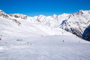 Kış mevsiminde kar ile kaplı kayak pistleri. Alp dağları. Mavi gökyüzü ile aydınlık bir kış günü. 