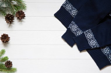 Noel fotokopi alanı. Kozalaklı firavun ağacı dalları ve beyaz ahşap arka planda mavi süveter. Üst görünüm. 