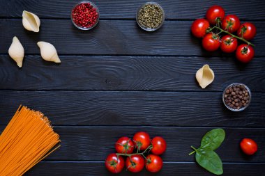 Makarna, büyük koni ve taze sebze. İtalyan mutfağı için malzemeler, üst manzara. Boşluğu siyah tahta arkaplanda kopyala. 